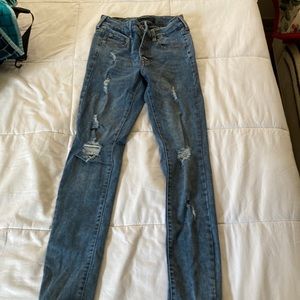 Dark blue jeans with rips and 4 buttons.